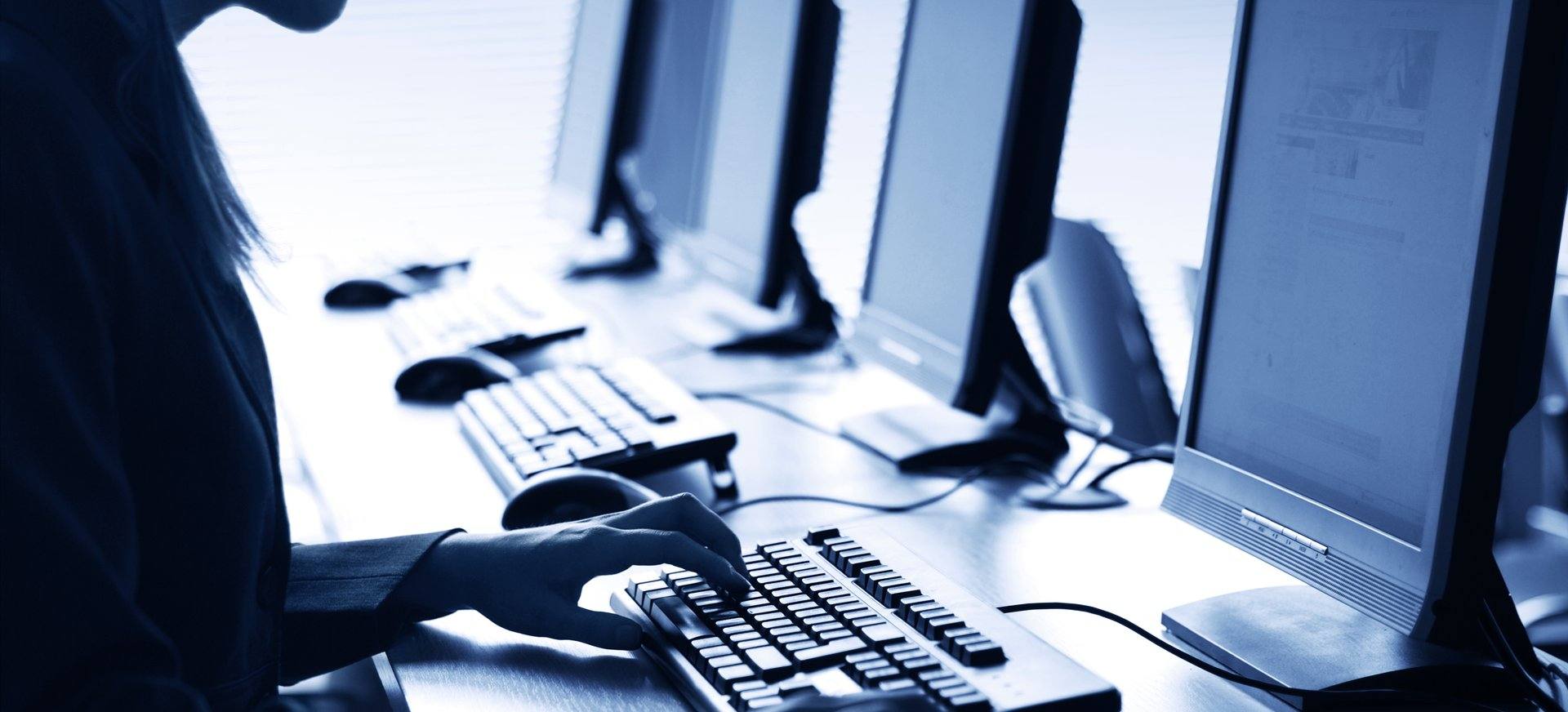 Technician working at a row of desktop computers